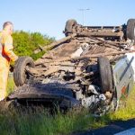 Busje rijdt lantaarnpaal omver en slaat over de kop